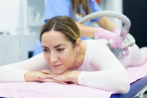woman in special white suit having a anti cellulite massage with spa apparatus